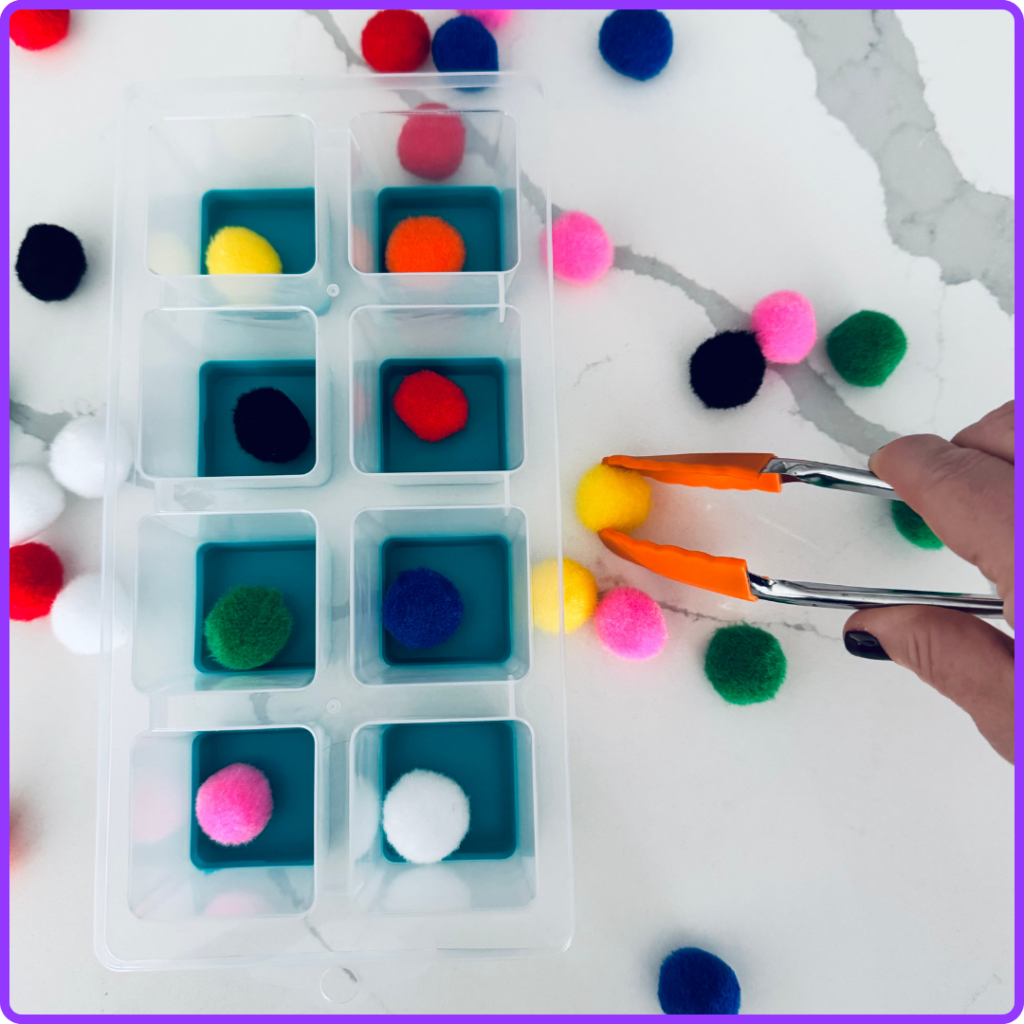 selecting a yellow pom pom for a colour match task box activity