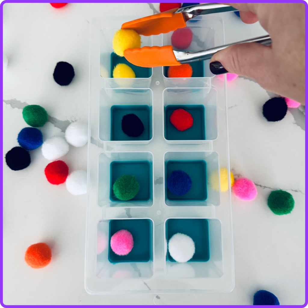 placing a yellow pom pom in the correct spot for a colour match task box activity